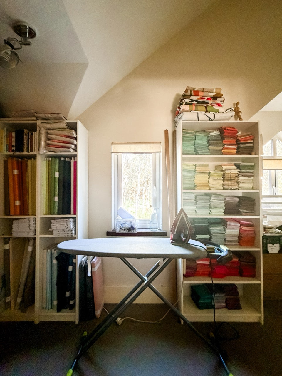Bolts of fabric and shelves of fabric in a textile artist's studio